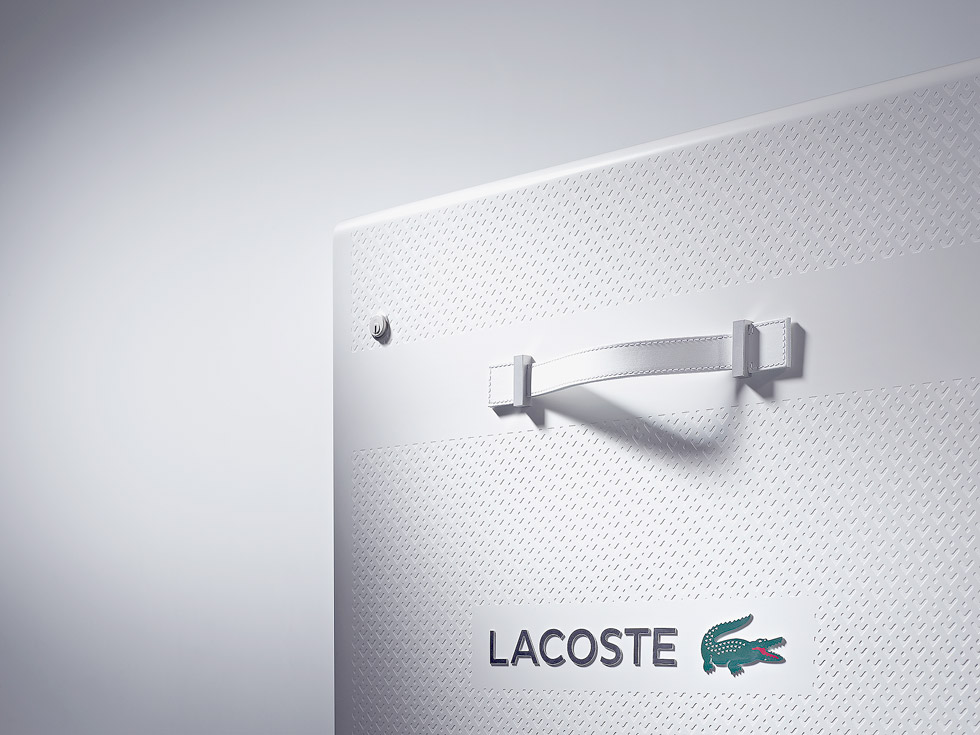 Detailaufnahme einer Ecke von einem weissen Koffer mit dem Logo von Lacoste.