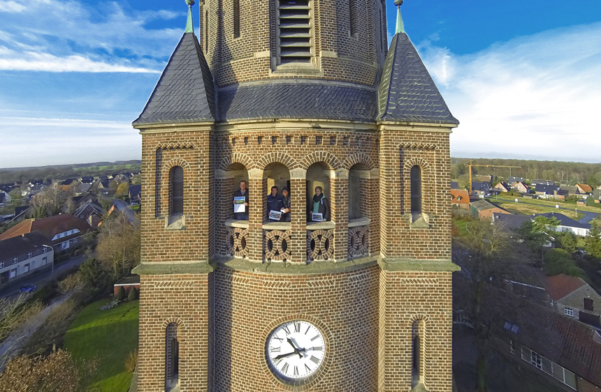 Teil eines Kirchturm auf Augenhöhe stehen 4 Menschen im Turm . Im Hintergrund sieht man Teile des Dorfes Hiddingsel.