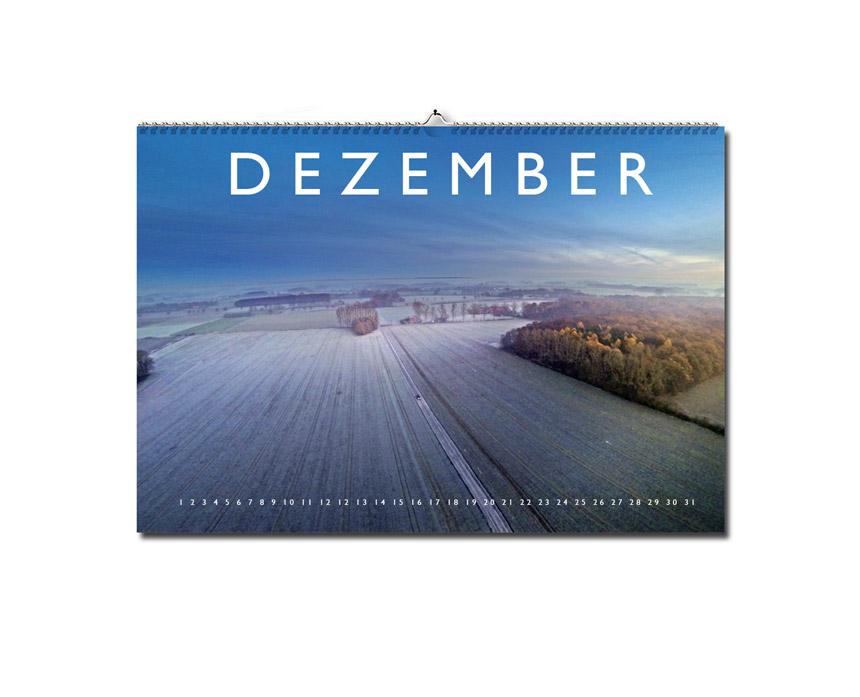 Luftaufnahme eines Feldes mit etwas Schnee bedeckt und dem Kalendarium von Dezember.