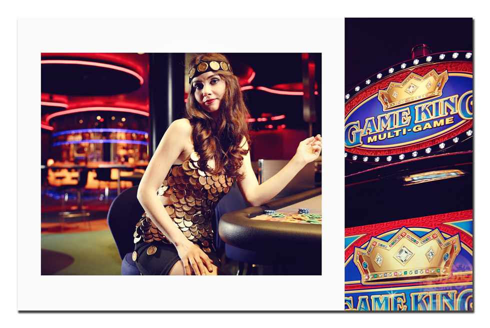 Frau mit langen braunen Haaren sitzt an einem Spieltisch im Casino. Ihr Kleid und Haarband sind aus Spieljetons gestaltet.