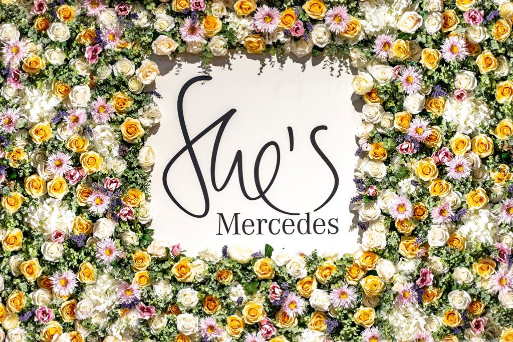 Schriftlogo von She´s Mercedes mit Blüten umrandet.