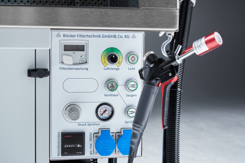 Beschriftetes Bedienfeld eines Absaugtisches von Böcker Filtertechnik mit Luftmengenregler, Druckanzeige und Sprühpistole
