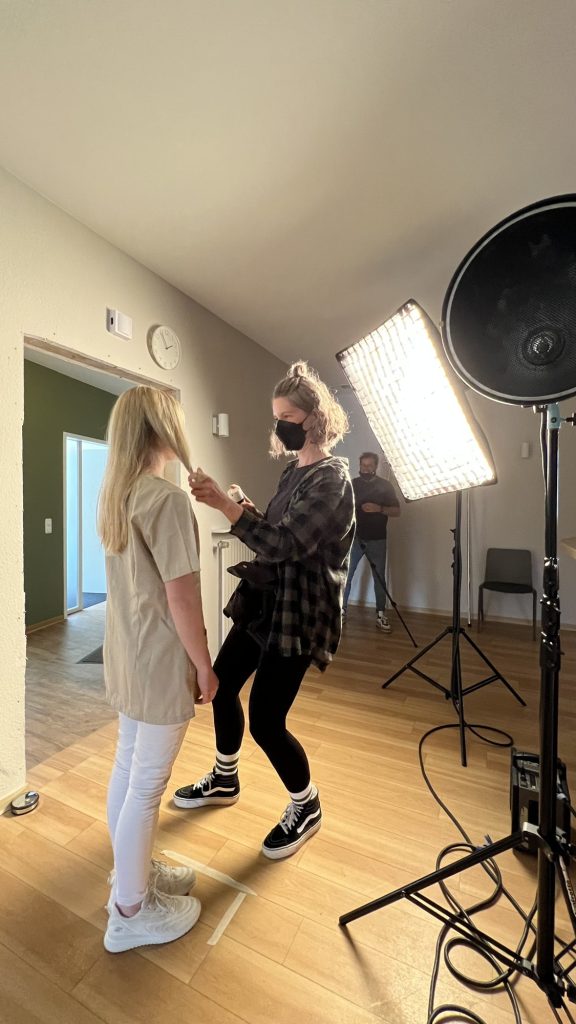 Making of: Visagistin bereitet eine Mitarbeiterin auf das Fotoshooting vor